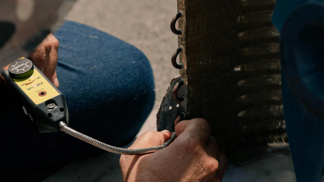 Klima dış ünitesinde ölçüm cihazıyla bakım kontrolü yapan teknisyen
